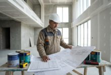 مهندس يراجع حساب كمية الدهانات داخل مبنى قبل أعمال التشطيب